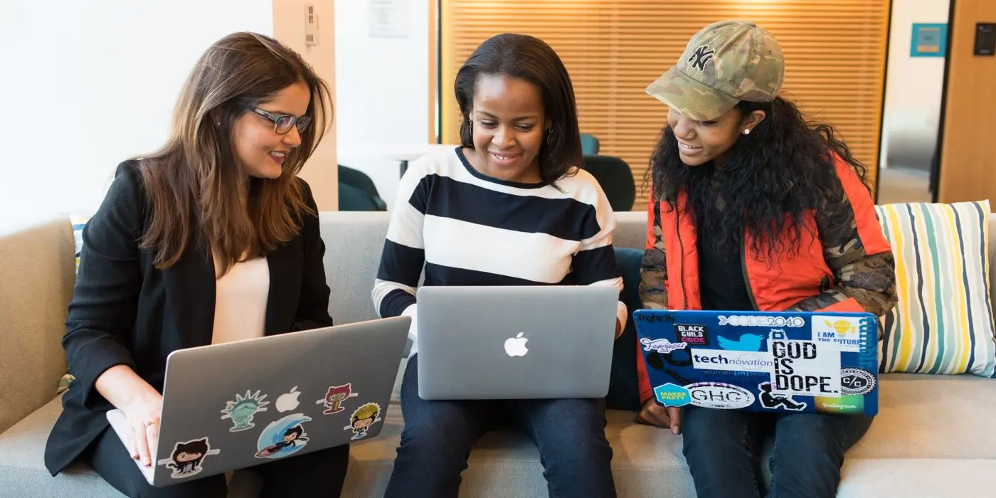 Three colleagues working together on laptops