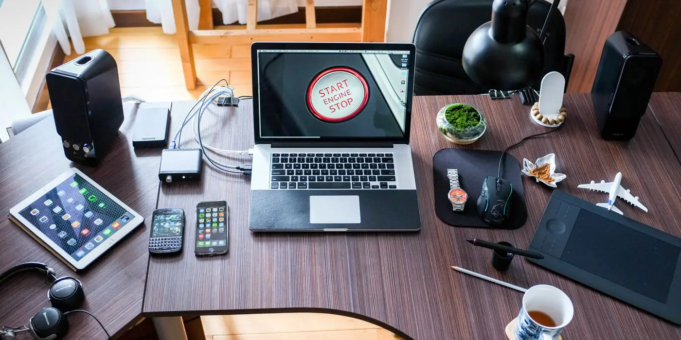 A developer’s desk with a laptop, tablet and phone