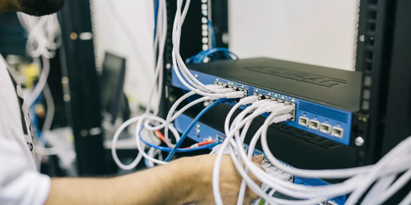 Engineer working on network cabling in a server room
